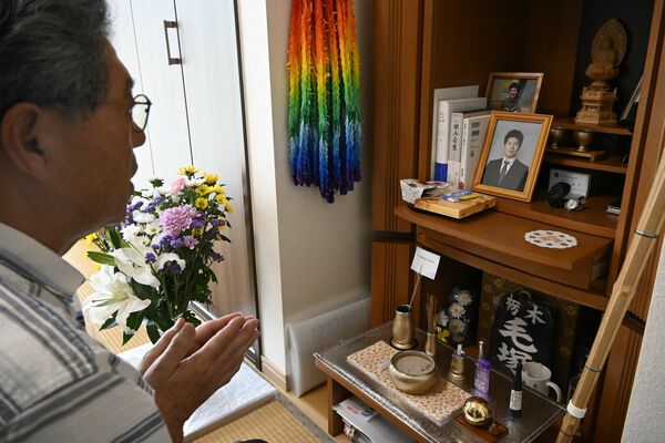 仏壇に手を合わせ、優甫さんに語りかける毛塚さん＝12日午後、栃木市