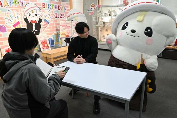 身振り手振りを交えインタビューに答えるさのまる