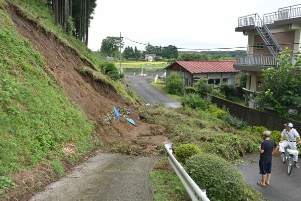 のり面が崩れて土砂などが道路を塞いだ＝26日午前７時50分、宇都宮市宮山田町