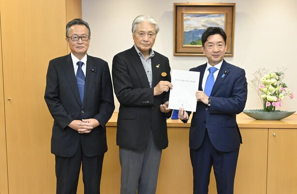 瀬戸副大臣（右）に要望書を手渡す福田知事（中央）＝７日午前、内閣府