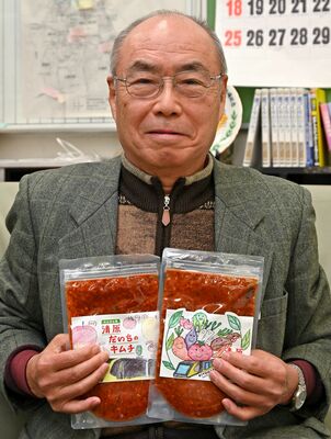 「清原だいちのキムチ」を手にする直井会長