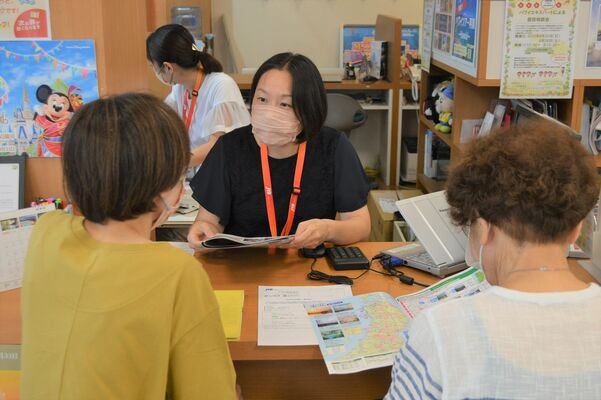 来店客に旅行を提案する代理店スタッフ。夏休みは国内外ともに長期化、遠距離化の傾向という＝19日午後、宇都宮市池上町