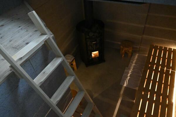 高低差のある座席でさまざまな温度が楽しめるまきストーブ式のサウナ