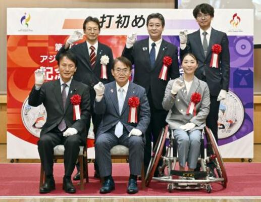 アジア・アジアパラ競技大会を記念した貨幣の打ち初め式で、写真に納まる愛知県の大村秀章知事(前列中央)ら=8日午後、大阪市の造幣局