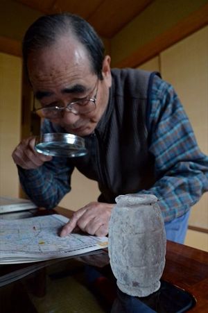 当時の中学生が教練で使った模擬手りゅう弾と宮岡さん。「１、２の３」と投げるタイミングは今も体が覚えている＝９日、宇都宮市越戸１丁目