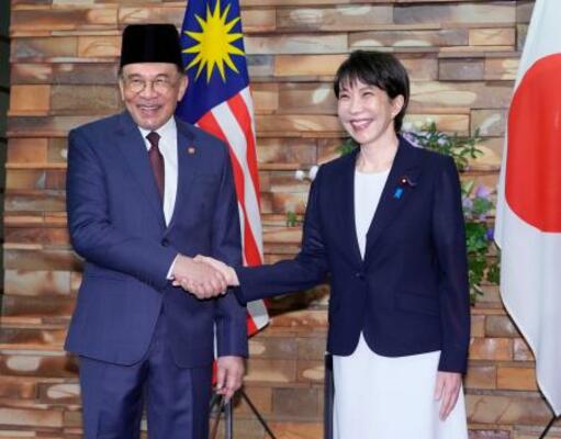 会談前に握手するマレーシアのアンワル首相(左)と高市首相=10日午前、首相官邸