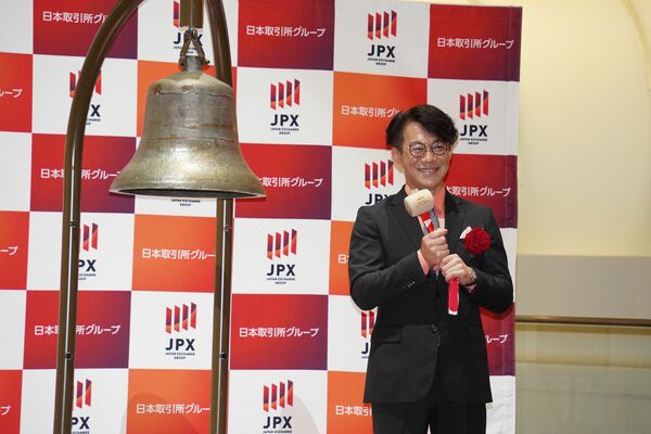 自社名が入った木槌を手に鐘の前に立つ森西社長＝４日午前、東京都内