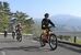 Ｅバイクで坂を上る君島さん（手前）ら。素晴らしい眺望を楽しめる＝４月28日午後、那須塩原市