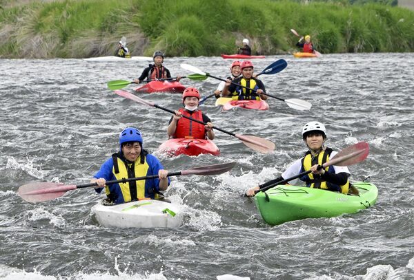 水しぶきを上げながらカヌーで那珂川を下る馬頭高の生徒たち＝22日午前10時10分、那須烏山市大桶