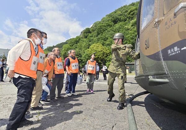 自衛隊ヘリを使って行われた訓練に参加する地域住民ら=13日午後1時25分、佐野市水木町、磯真奈美撮影