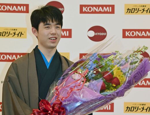 花束を手に笑顔を見せる藤井六冠＝19日午後９時10分、日光きぬ川スパホテル三日月