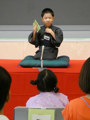 ユーモアたっぷりに落語を演じる児童