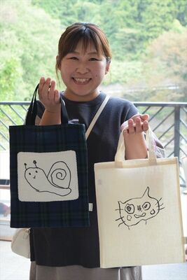 結花さんのイラストが転写された作品を手にする文奈さん