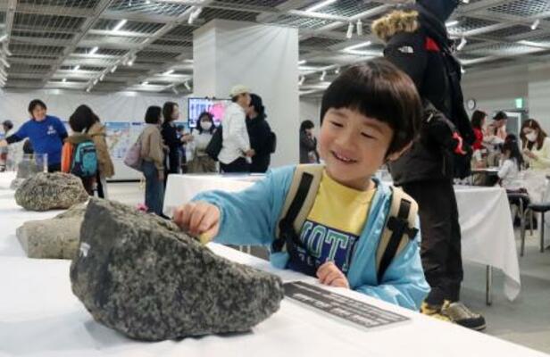 南極について学ぶイベントで、岩石に触れる子ども=21日午後、広島市中区