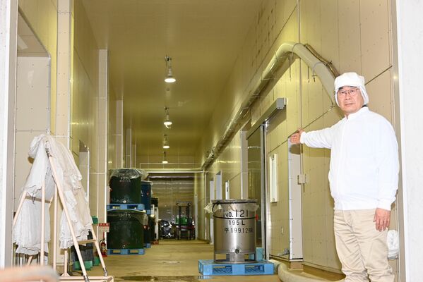 ２０１３年12月に全面的に建て替えた醸造蔵と尾崎社長＝３月上旬、大田原市