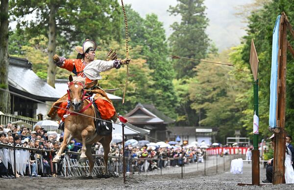 木々も色づき始めた表参道で行われた「流鏑馬神事」=16日午後1時40分、日光市山内