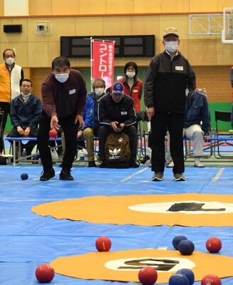 床の的に向かってボールを投げる参加者＝10日午後、宇都宮市若草１丁目