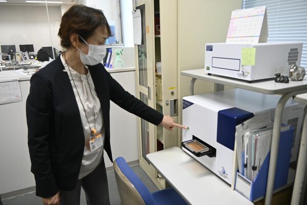 追加する検査用の機器を操作する県保健衛生事業団の担当者＝26日午後、宇都宮市駒生町