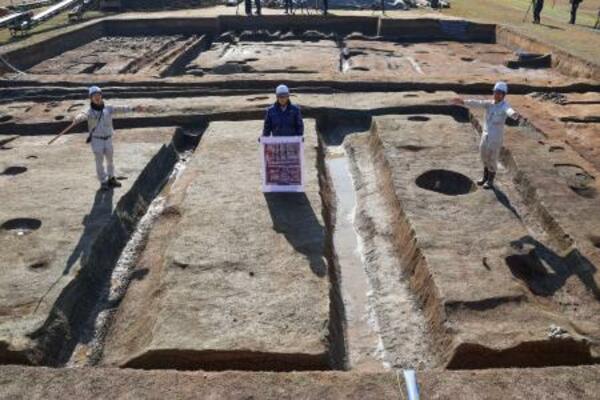 藤原宮跡の調査区画で「大極殿院」の西門の幅を示す研究員ら=27日午前、奈良県橿原市