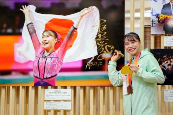 「2025年報道写真展」で、自身の写真にサインする体操女子の杉原愛子選手=10日午前、東京都中央区の日本橋三越本店