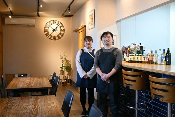 木目を基調とした店内に立つ佐山さんと妻の香織さん