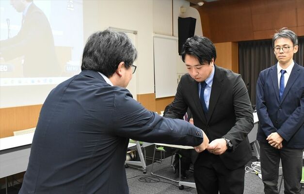 授賞式で賞状を受け取る伊藤記者（中央）＝23日夕方、東京都内