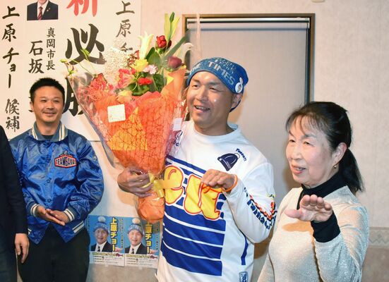 初当選を決め、母ミサトさんとポーズを取る上原亮氏（中央）＝23日午後10時半、真岡市並木町４丁目