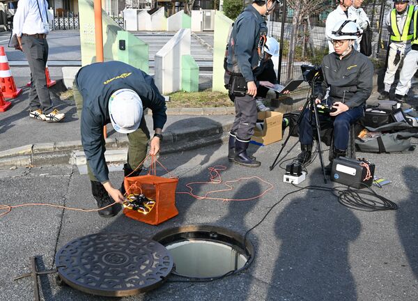 ドローンを使った下水道管点検。ドローンを網状の袋に入れて地下に運び、管路内を飛行させた