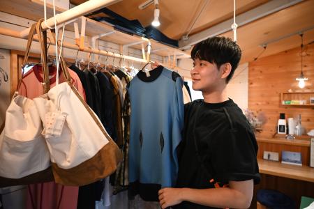 　自らデザインした服のコンセプトを説明するヒキノユウタさん＝２０２５年７月