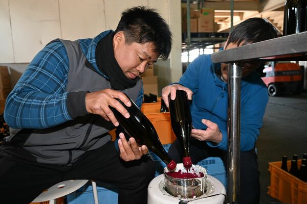 コルク栓にロウを付ける岩崎さん＝１１日午後、足利市