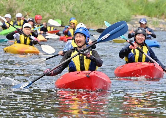 那珂川の清流をカヌーで下る馬頭高の生徒たち＝25日午前11時50分、那須烏山市滝田
