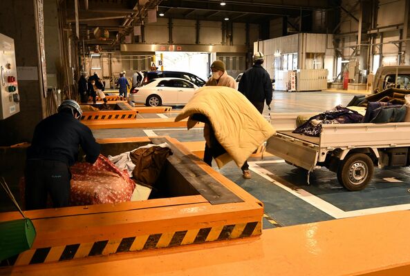 稼働再開を受け、可燃ごみを持ち込む市民ら＝24日午前、宇都宮市茂原町