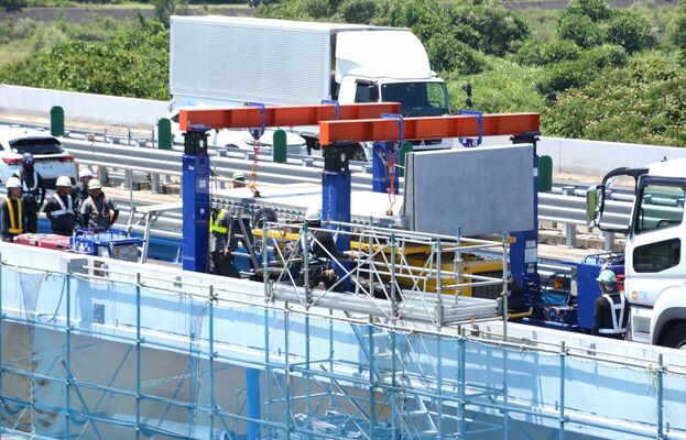 新しい床版の吊り上げを行う作業員ら＝23日午前11時40分、さくら市押上