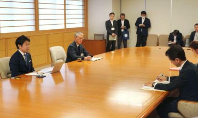 　資源エネルギー庁の久米孝電力・ガス事業部長（右）から報告を受ける宮下宗一郎青森県知事（左）＝３日午後、青森県庁