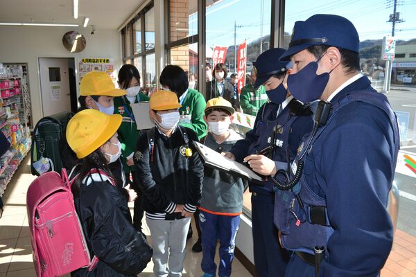 コンビニに駆け込み、警察官に事情を話す大月小の子どもたち