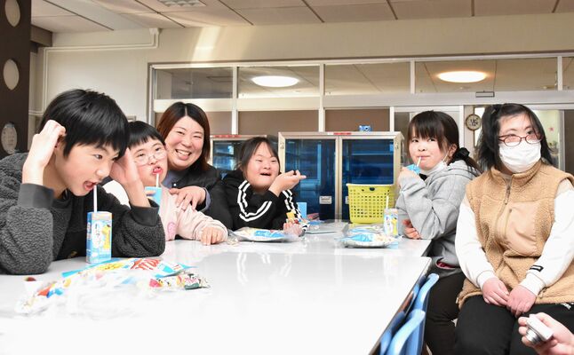 スライドショーを見つめ、笑顔で寄宿舎生活を振り返る入舎生ら＝26日午後、那須特別支援学校