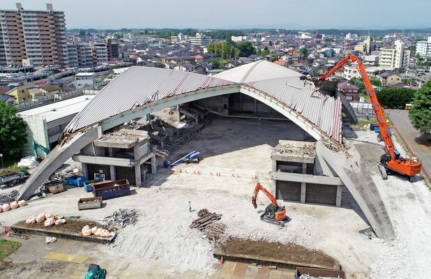 大型重機によって屋根などの解体が進む県体育館＝24日午前９時50分、宇都宮市中戸祭１丁目、ドローンから
