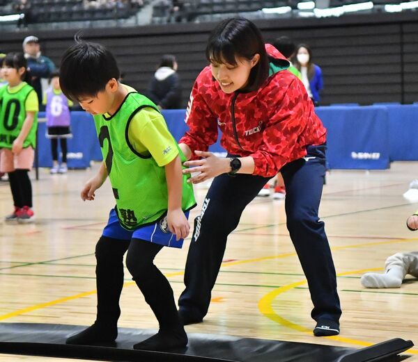 後ろで支えながらスケートの滑り方を教える上鹿渡