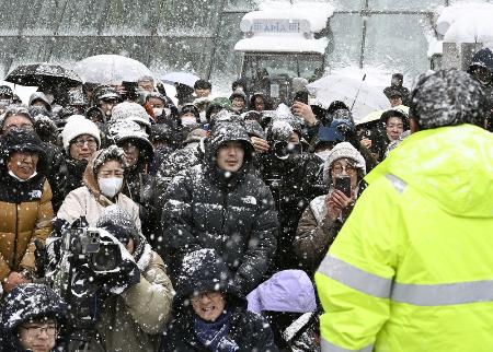 　雪の降りしきる北海道で、候補者の街頭演説に集まった人たち＝１月31日