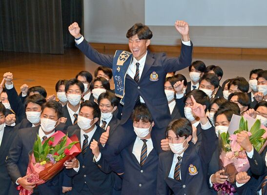白鴎大野球部のチームメイトから祝福を受ける曽谷＝20日午後６時15分、小山市の同大本キャンパス