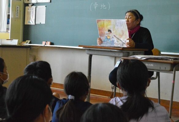 子どもたちに絵本を読み聞かせする辻元さん＝８月下旬、那須町大島