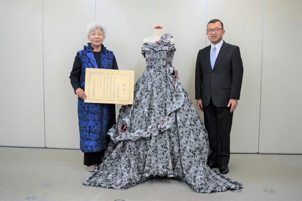 受賞したドレスを持って町役場を訪れた小平さん（左）と星野町長