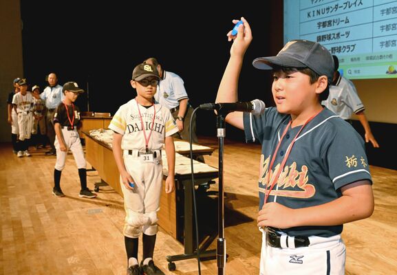 抽選後、くじの番号を会場内に発表する各チームの主将たち＝20日午後３時５分、県教育会館