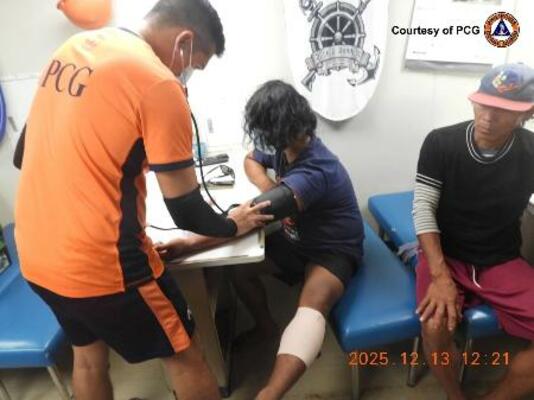 南シナ海で負傷し、手当てを受けるフィリピン漁船の漁師=13日(フィリピン沿岸警備隊提供・AP=共同)