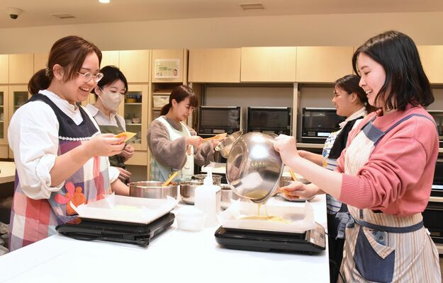 アドバイスを受けながら、ケーキの生地を作る生徒ら＝20日午後７時、宇都宮市駅前通り１丁目