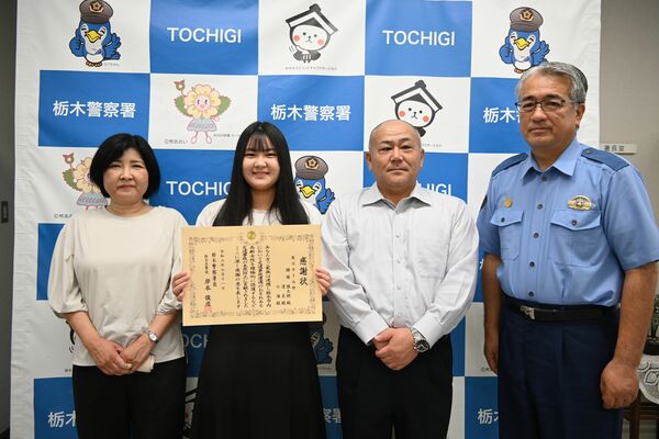 岸本署長（右）から感謝状を受け取った腰塚さん一家