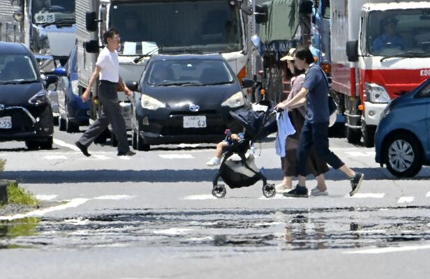 今年初の猛暑日となり、路面に出現した「逃げ水」＝14日午前11時35分、佐野市高萩町