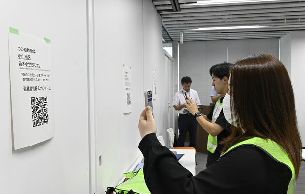 QRコードを読み取る避難者役の職員