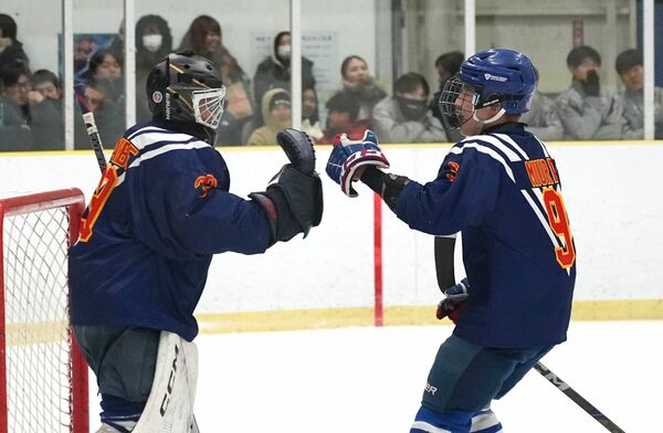 アイスホッケー２回戦　３得点を挙げたＦＷ三浦（右）と無失点に抑えたＧＫ渡辺がハイタッチ＝細尾ドームリンク、橋本裕太撮影