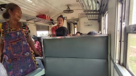 　バンコクから約２５０キロ離れた東部の町へ向かう列車内で商品を販売する女性（左）＝５月１６日